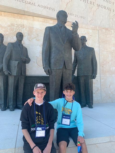 Students posing with statue 